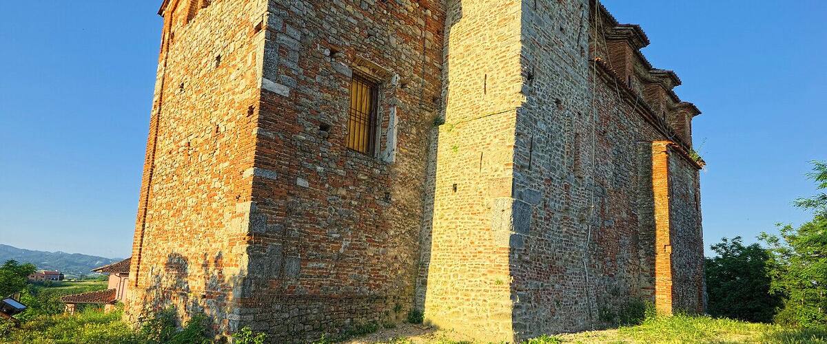 An old stone church with a bell tower and a small arched window.