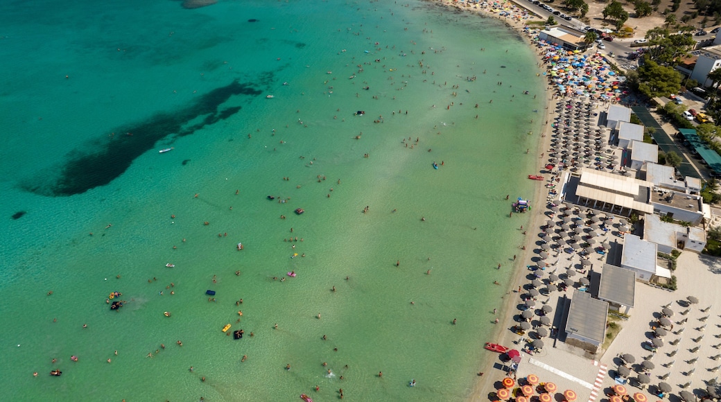 Aerial view of the beach clubs of Sant' Isidoro in the province of Lecce in Salento, Puglia, Italy. The beach is crowded on this beautiful summer day. The sea water is clean and crystal clear.