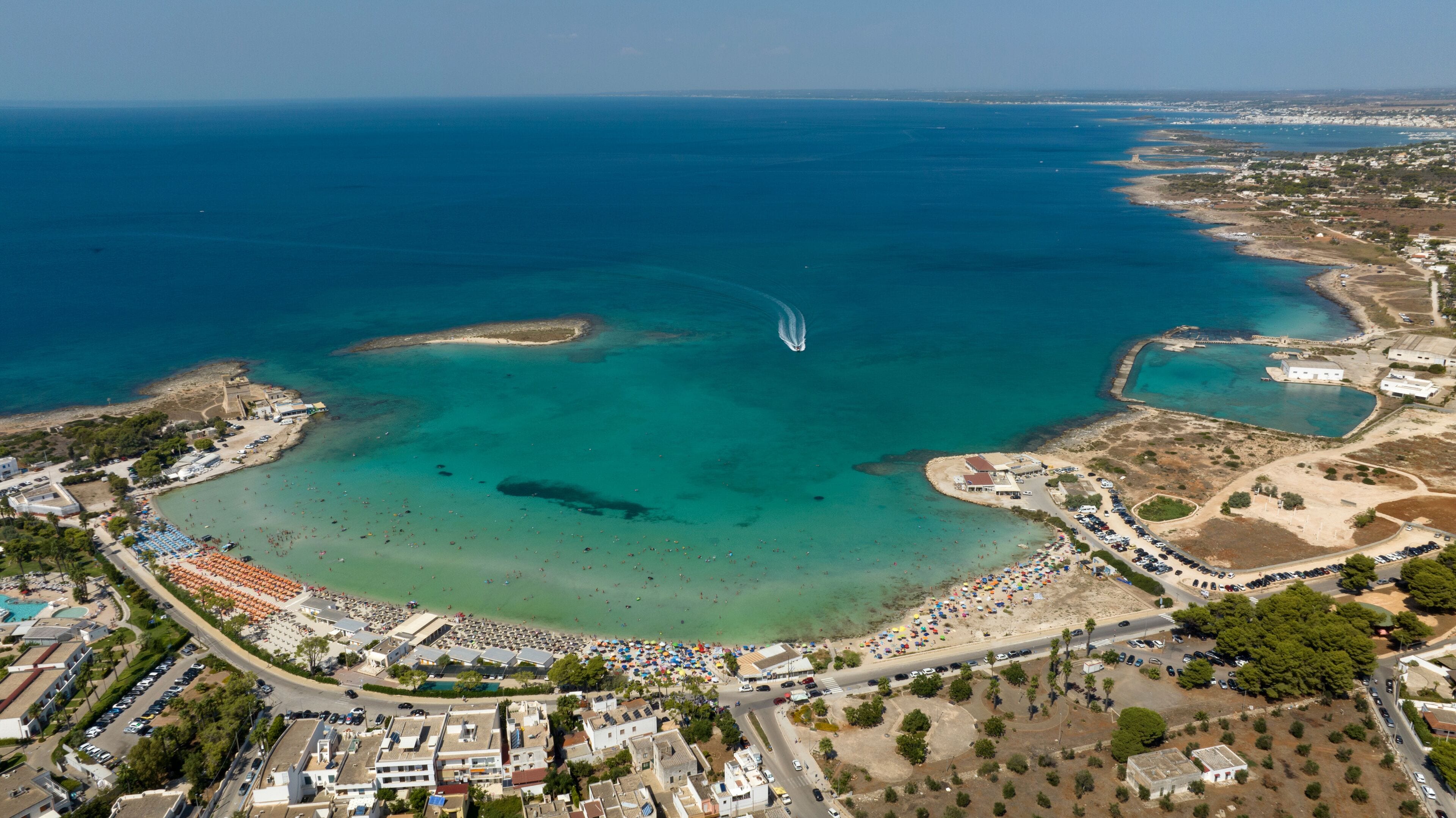 Aerial view of Sant' Isidoro beach in the province of Lecce in Salento, Puglia, Italy. In the background there is the small island of Sant' Isidoro in the middle of the clean and crystalline sea