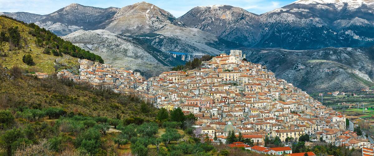 A mountainous town with terraced buildings and a prominent church.