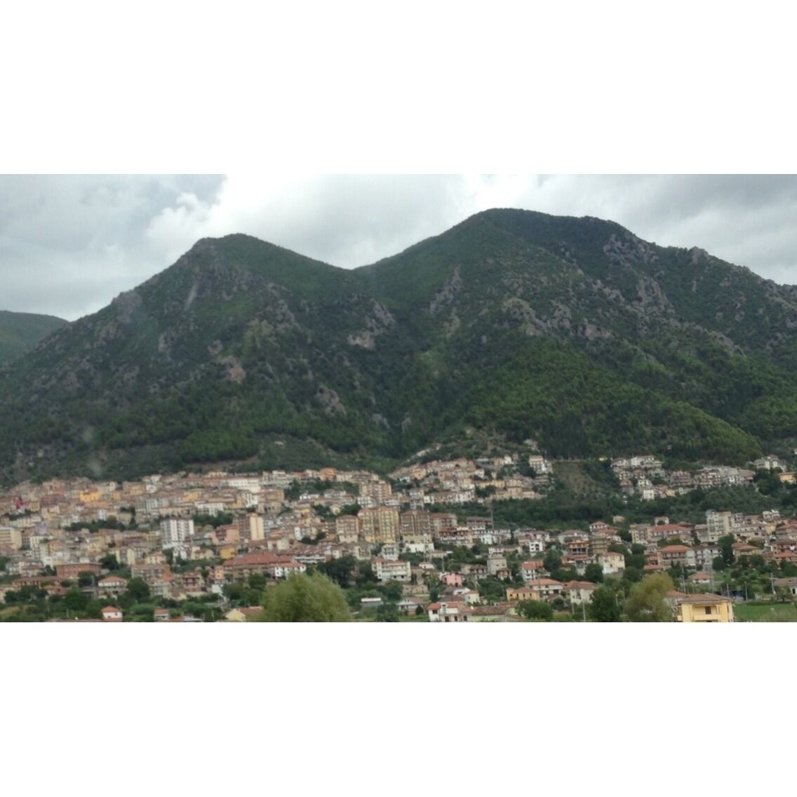A mountainous landscape with a densely built town in the foreground.