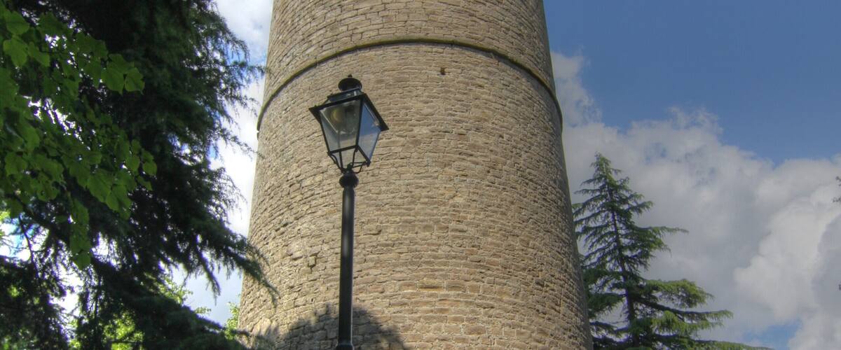 A tall stone tower with a lantern post in front.