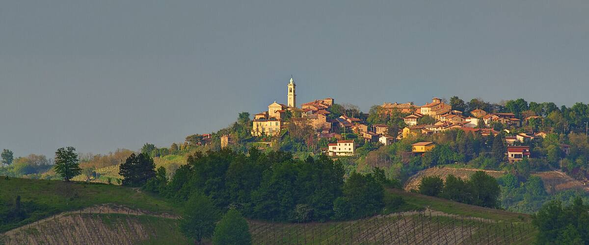 A hillside village with historic buildings and a prominent church tower.