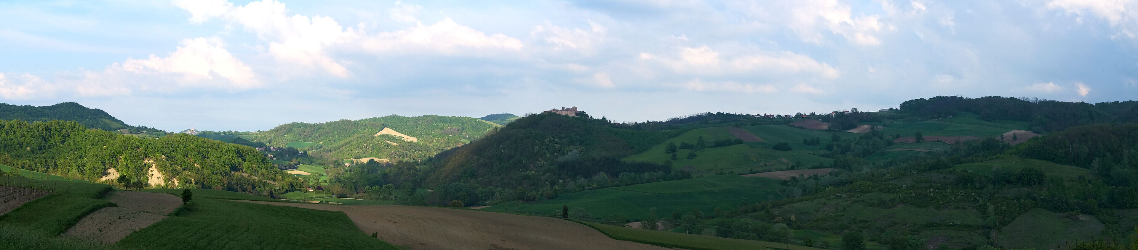 Rolling hills, a castle on a hill, and a field.