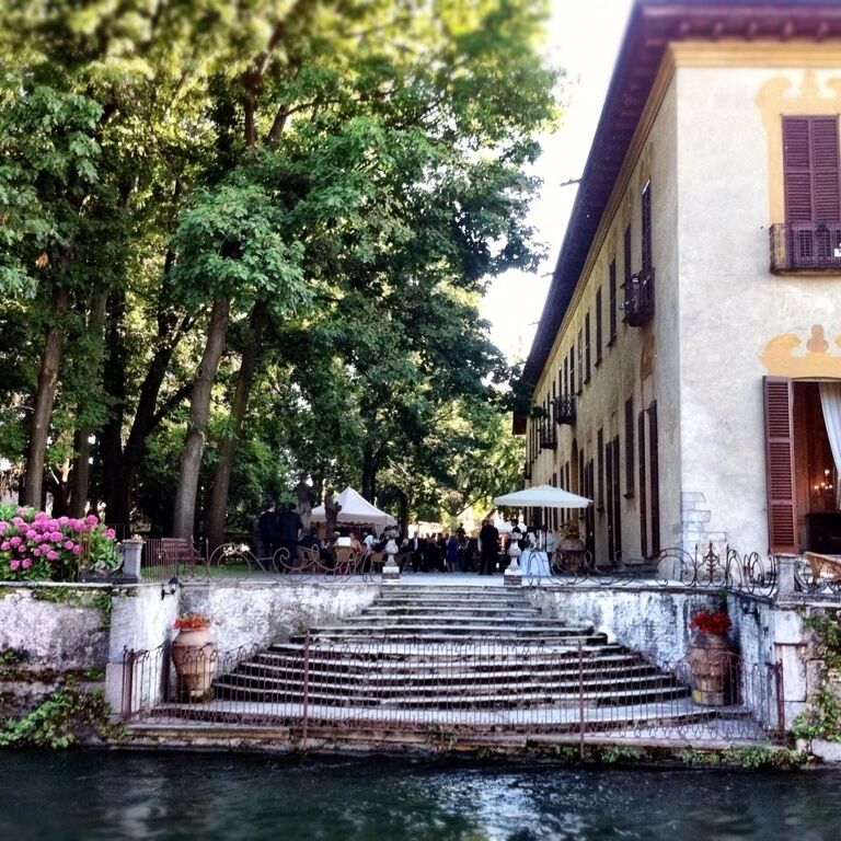 A canal with steps leading to a building with a balcony.