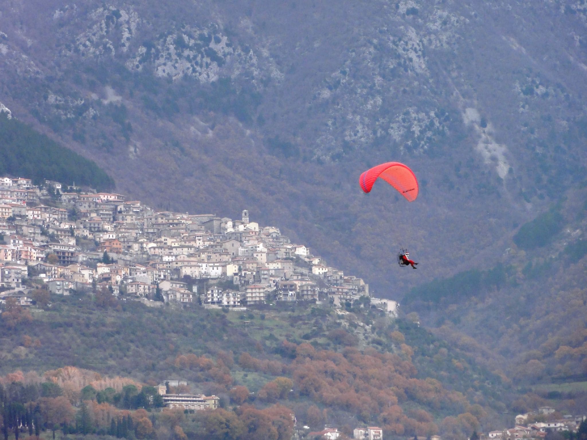 Un parapendio in volo dalla montagna dove sorge Poggio Bustone (provincia di Rieti, Lazio) in discesa verso la Piana Reatina