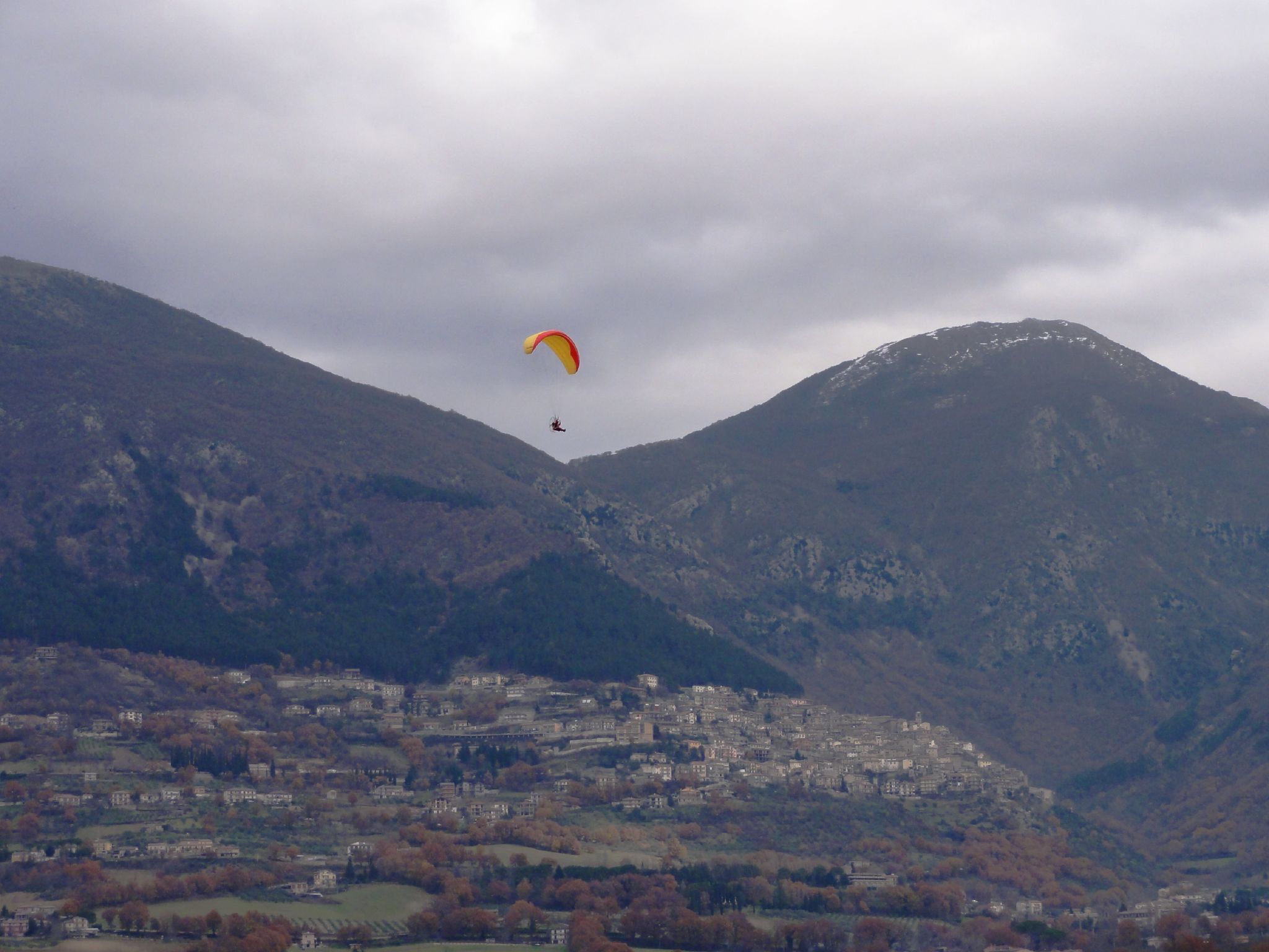 Un parapendio in volo dalla montagna dove sorge Poggio Bustone (provincia di Rieti, Lazio) in discesa verso la Piana Reatina