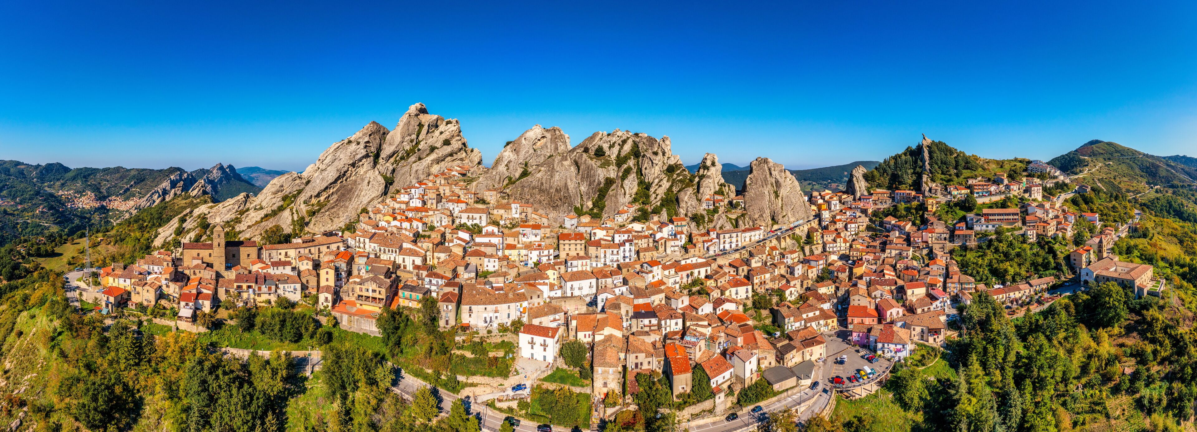 A town nestled in a valley surrounded by rugged mountains.