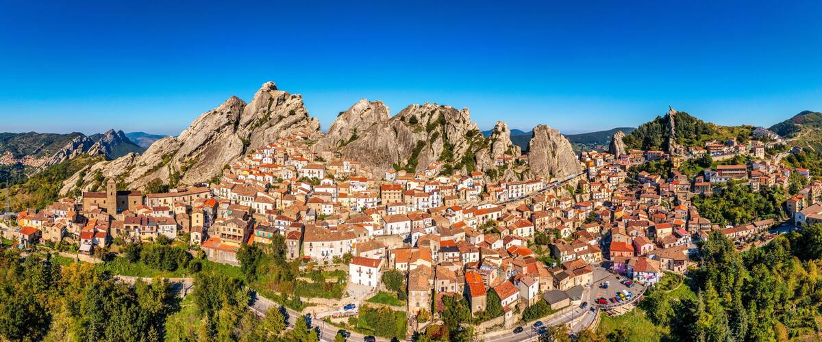 A town nestled in a valley surrounded by rugged mountains.