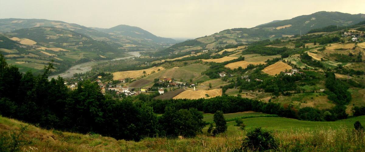 Rolling hills, a river, and scattered houses in a valley.