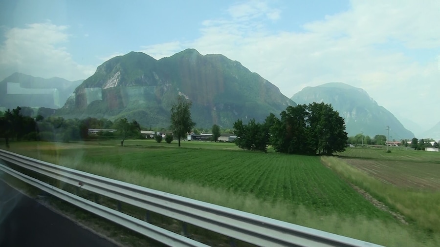 Paisaje rural con montañas, campos y casas dispersas.