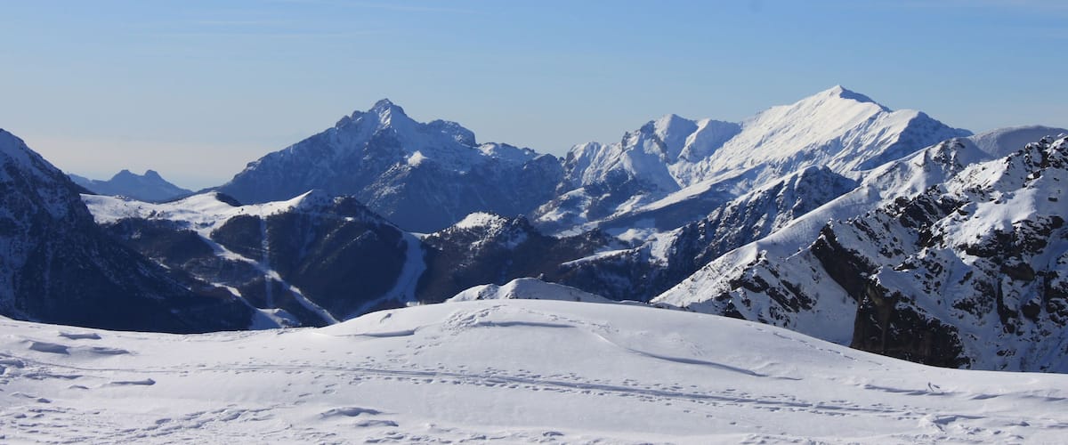 A snow-covered mountain range with clear skies.
