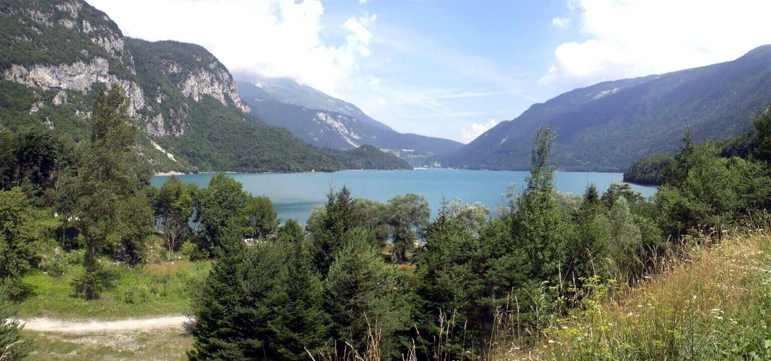 A lake surrounded by mountains and dense forest.