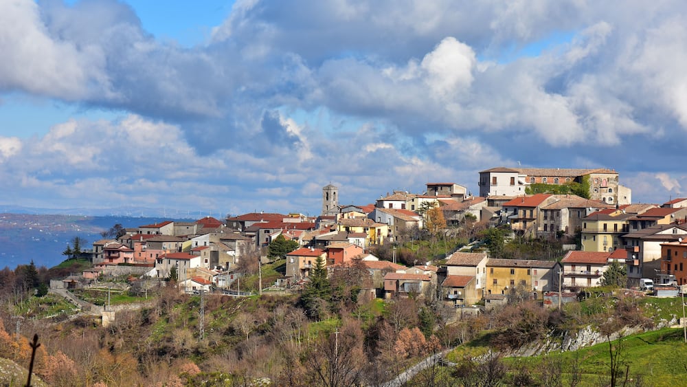 A hillside village with colorful buildings and a church.