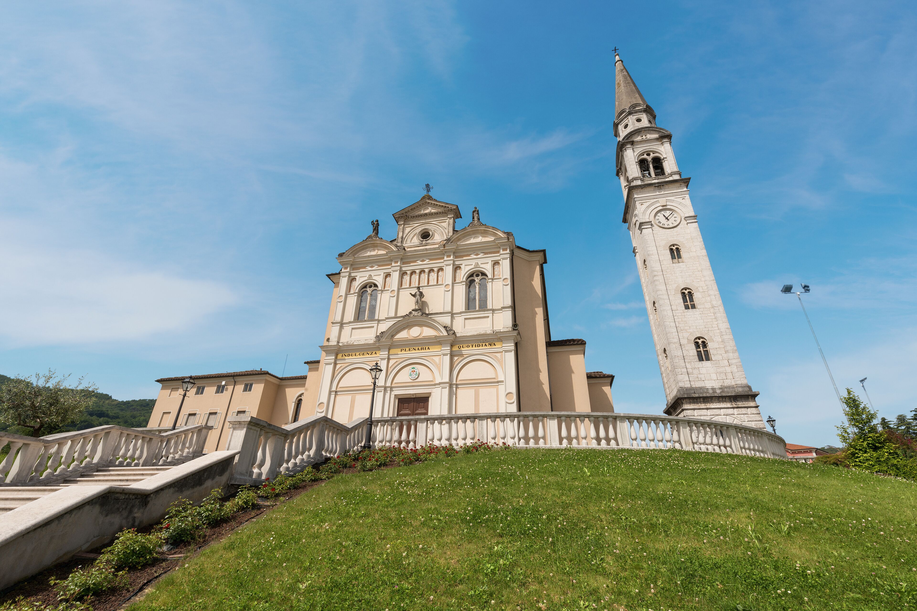 A historic church with a bell tower and a staircase leading up to it.