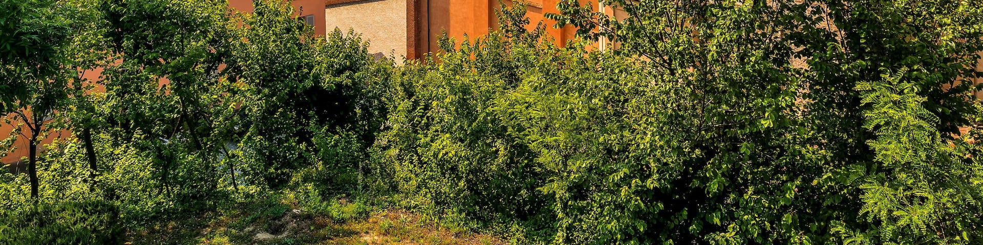 Old brick belfry under blue sky in small town in Italy.