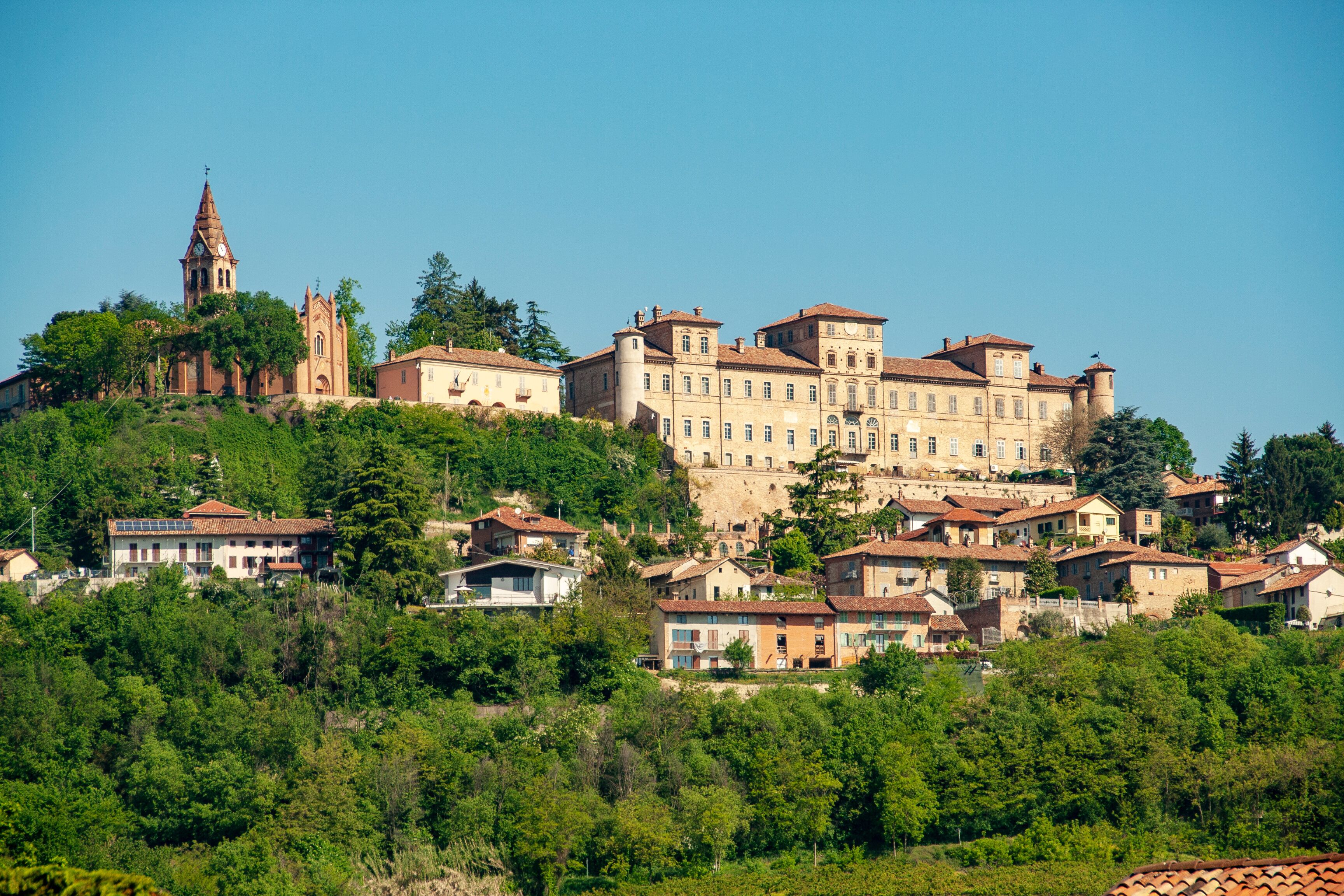 A historic hilltop town with a prominent church and castle-like building.