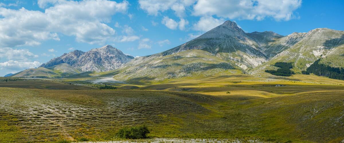 A mountainous landscape with rolling hills and a clear sky.