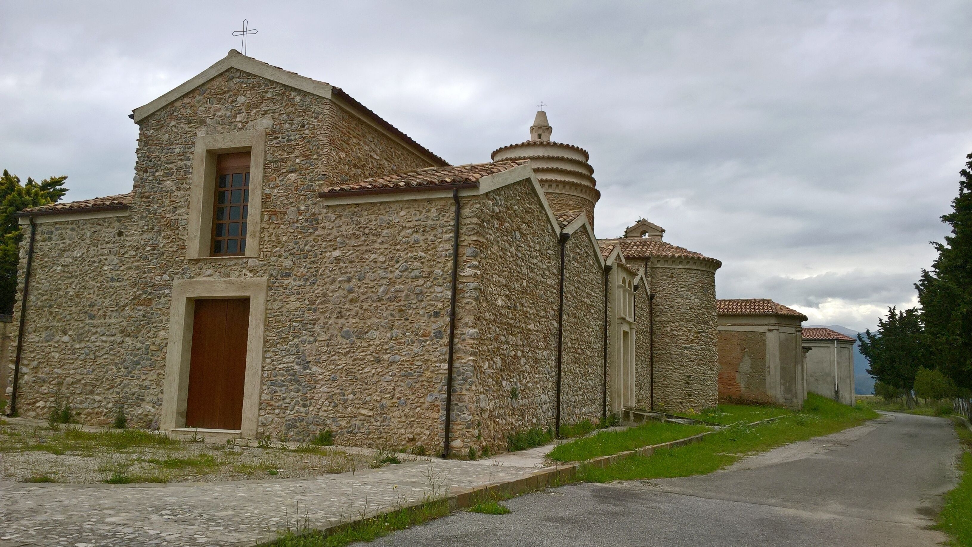 A stone church with a bell tower and a wooden door.