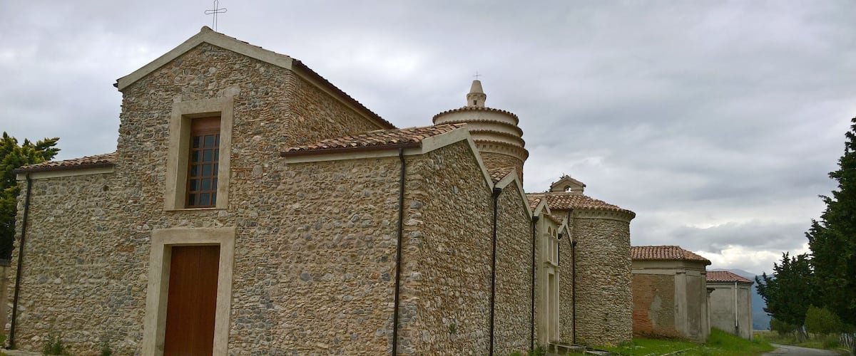 A stone church with a bell tower and a wooden door.