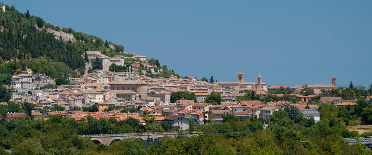 A coastal town with historic buildings, a prominent church, and a bridge.