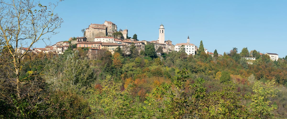 A historic town with a prominent castle and a church on a hill.