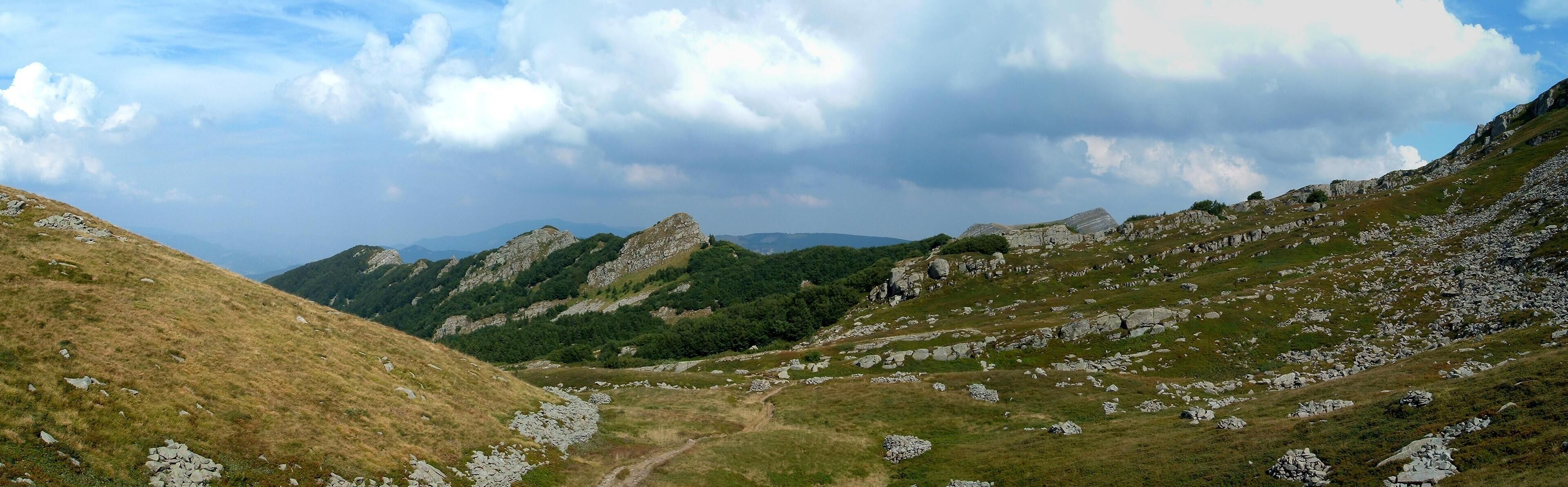 A mountainous landscape with rocky terrain and patches of grass.