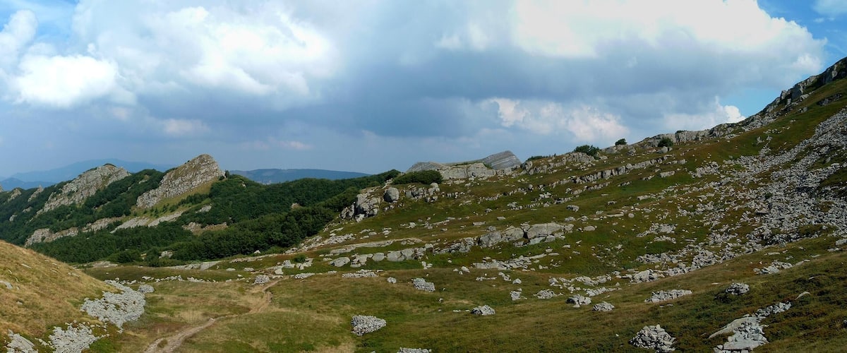 A mountainous landscape with rocky terrain and patches of grass.