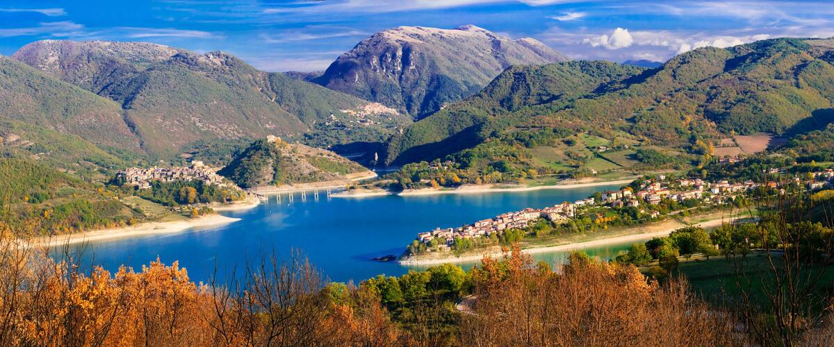 A mountainous landscape with a lake, a bridge, and a town.