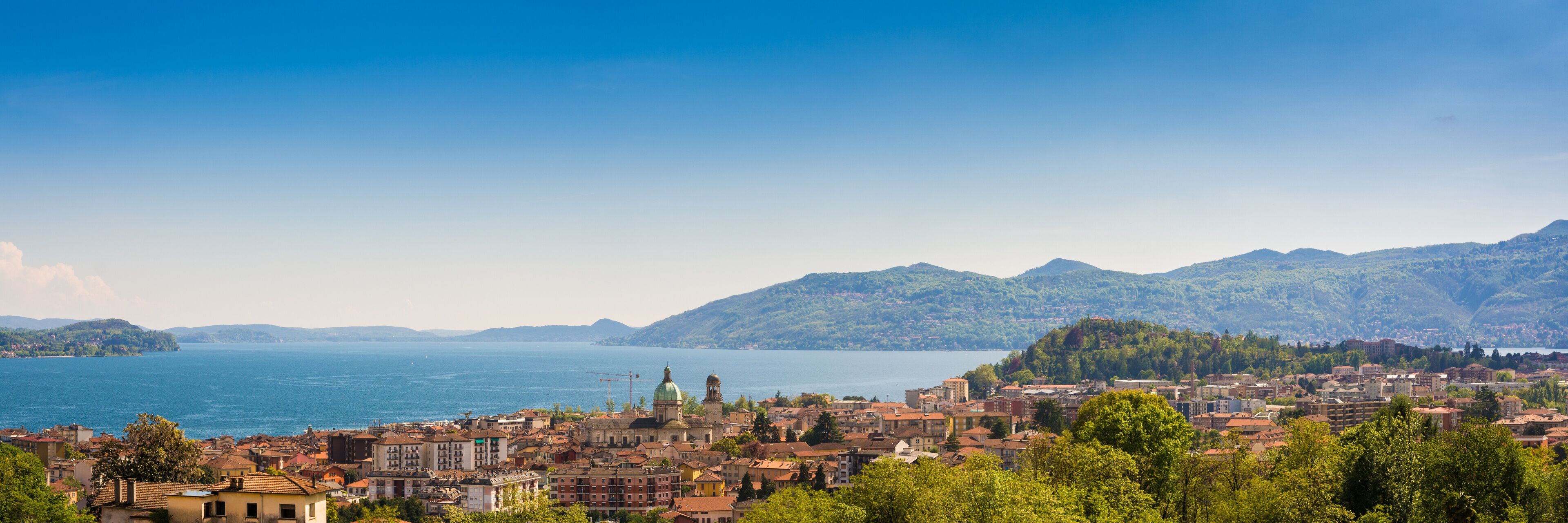 A coastal city with a prominent church, a large body of water, and surrounding mountains.