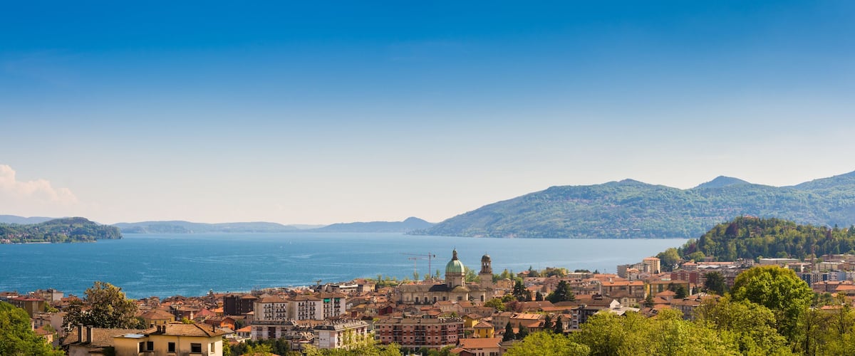 A coastal city with a prominent church, a large body of water, and surrounding mountains.
