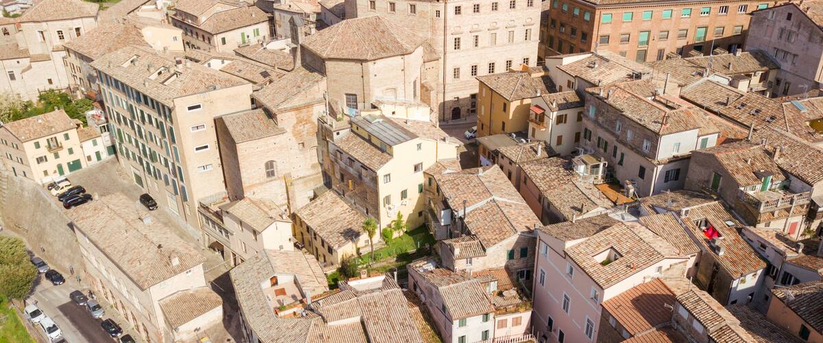 An aerial view of a densely packed historic town with narrow streets and closely built buildings.