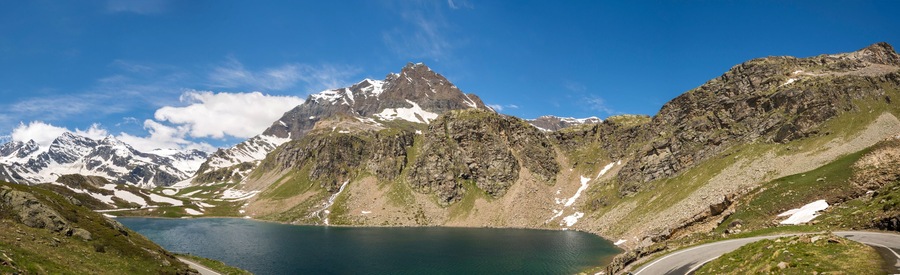 A mountain lake with a winding road and a prominent peak.