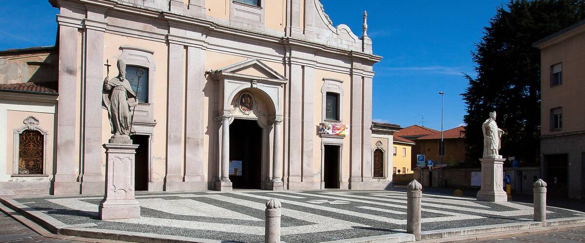 A historic church with a bell tower and statues in front.