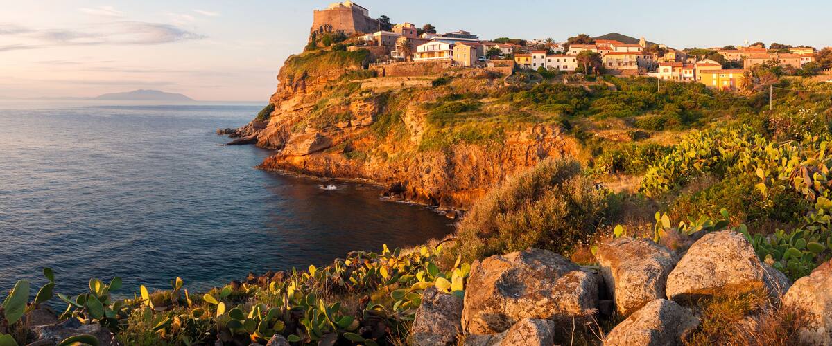 A coastal town with a historic fort on a cliff overlooking the sea.