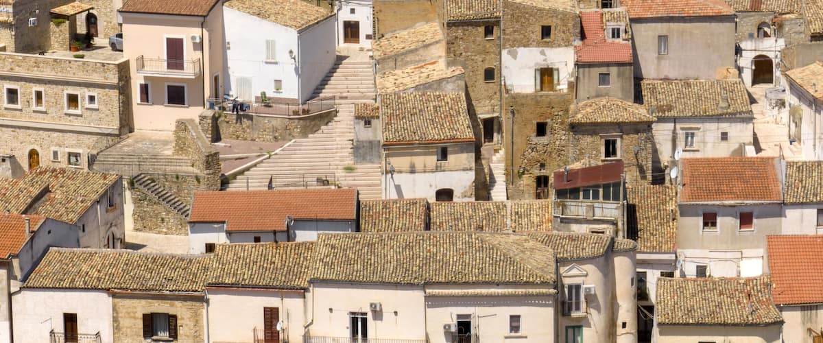 A densely packed village with stone buildings and terracotta roofs.