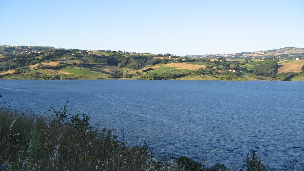 A lake with surrounding hills and scattered houses.