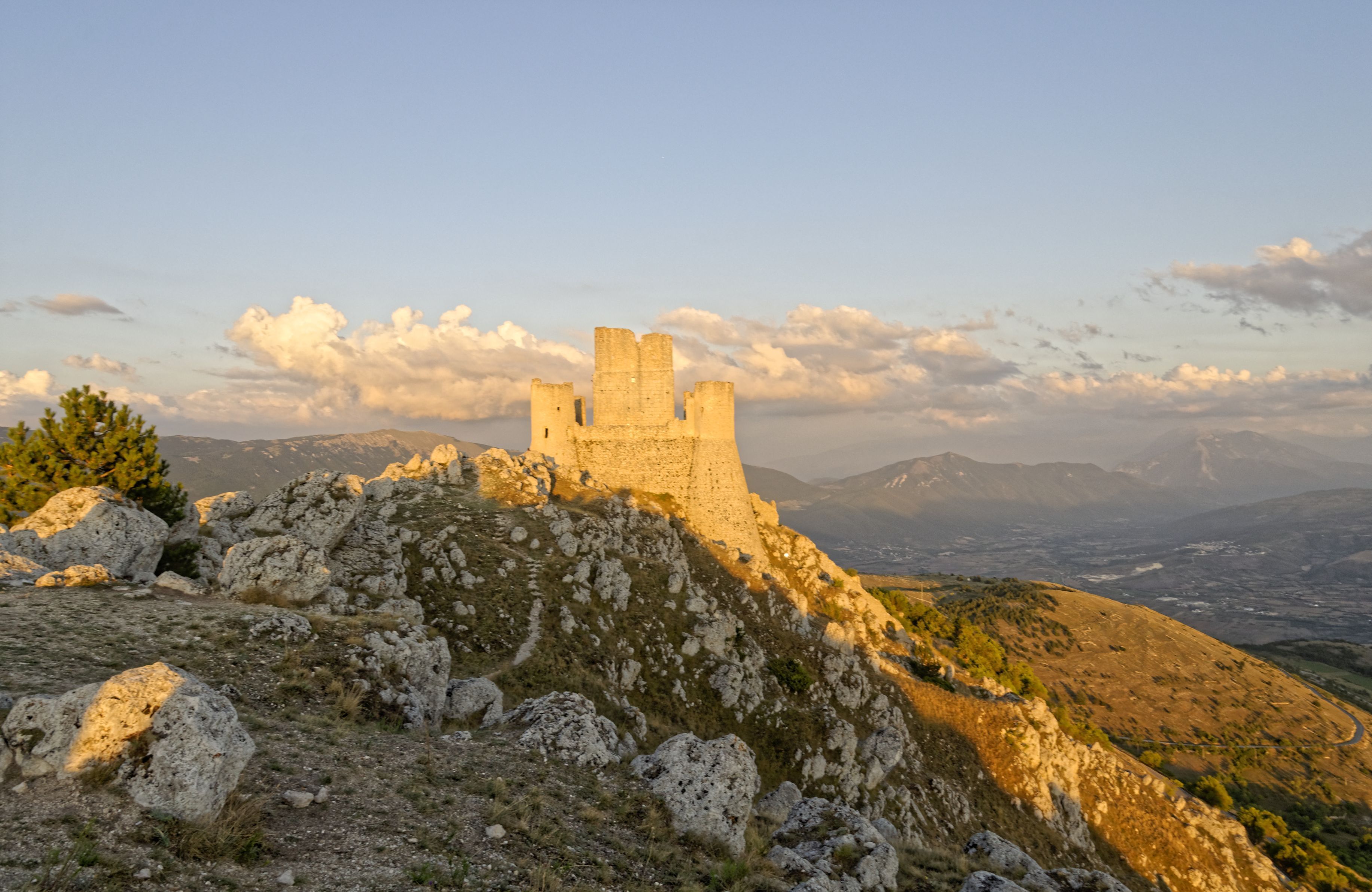 A medieval castle on a hill with a clear sky.