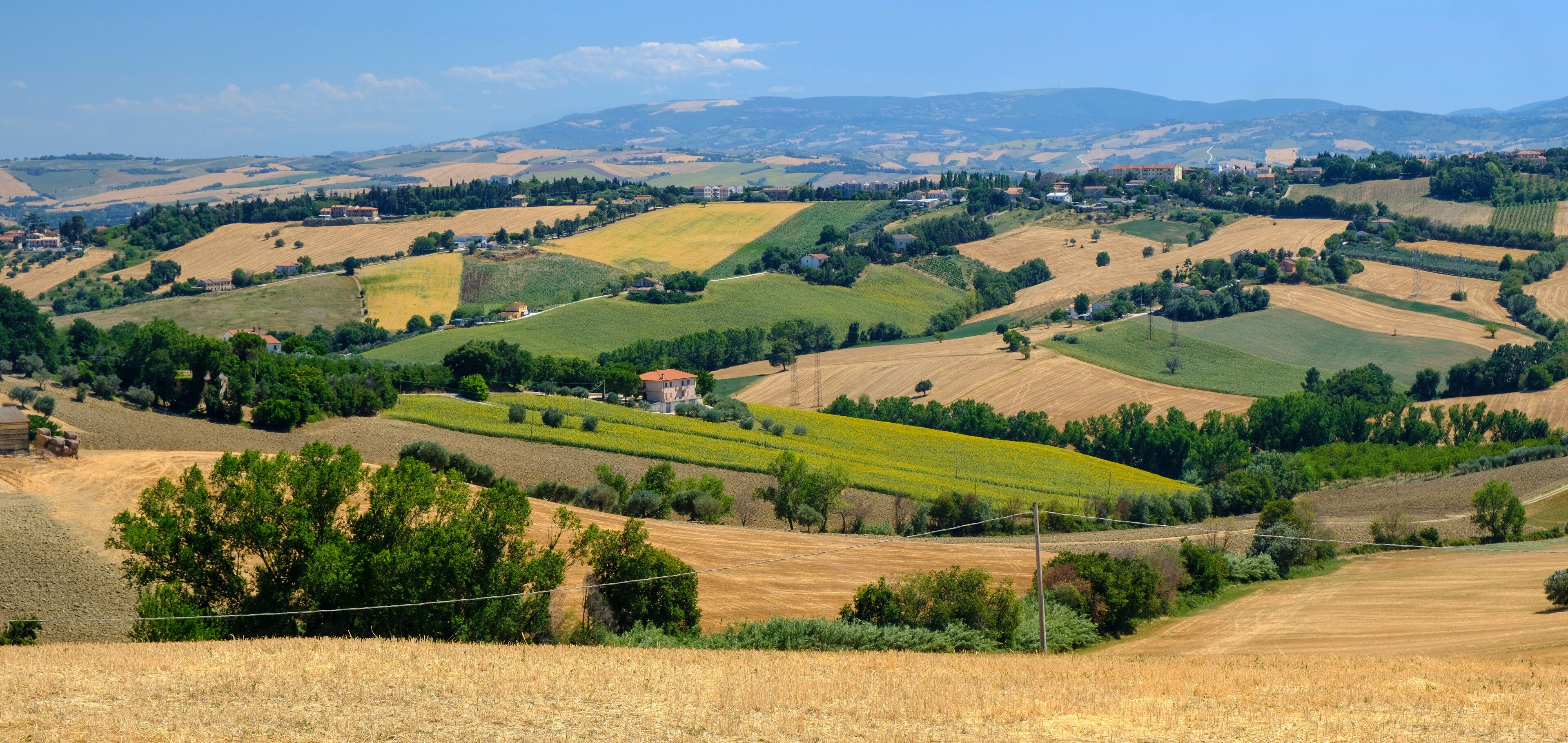Rolling hills, fields, and scattered houses in a rural landscape.