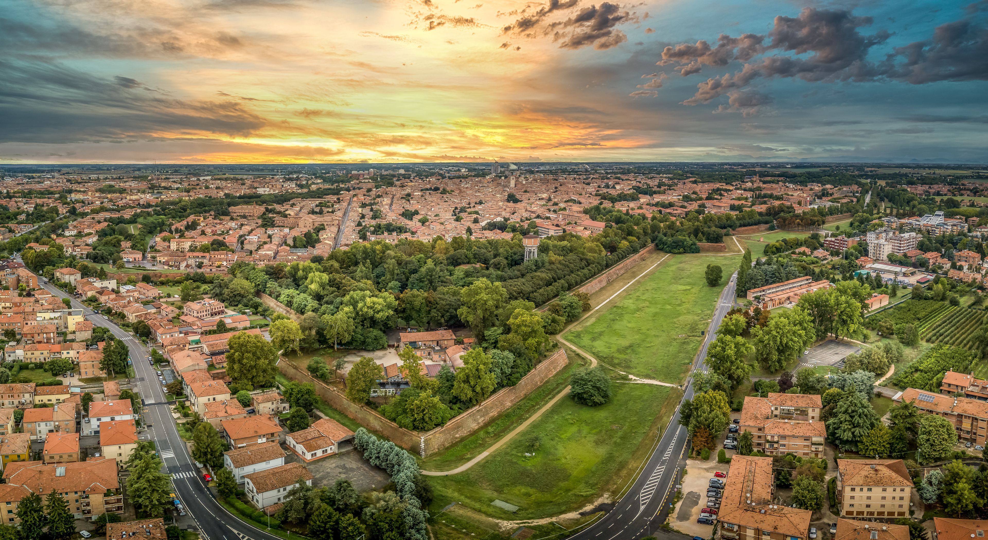 Aerial sunset panorama of the bastions and medieval wall of the center of Ferrara Italy with stunning yellow, blue sky colors