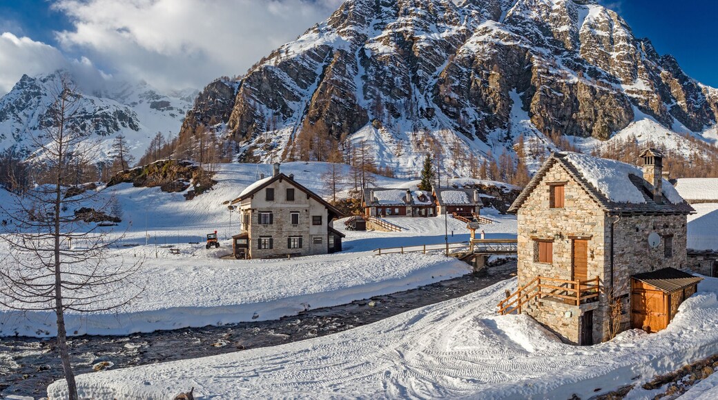 Panoramic view of the sunny snow-covered landscape of the village of Crampiolo, above the Alpe Devero in Piedmont, Italy.
