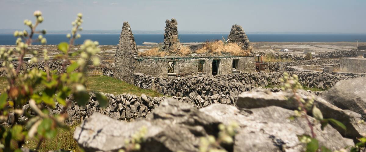 A stone ruin with a view of the sea in the background.