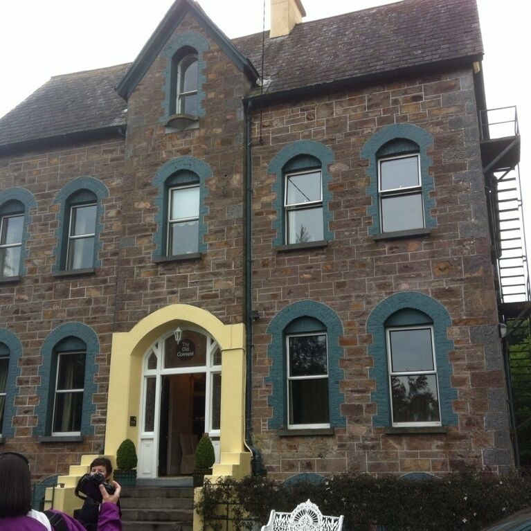 A stone building with arched windows and a yellow entrance.