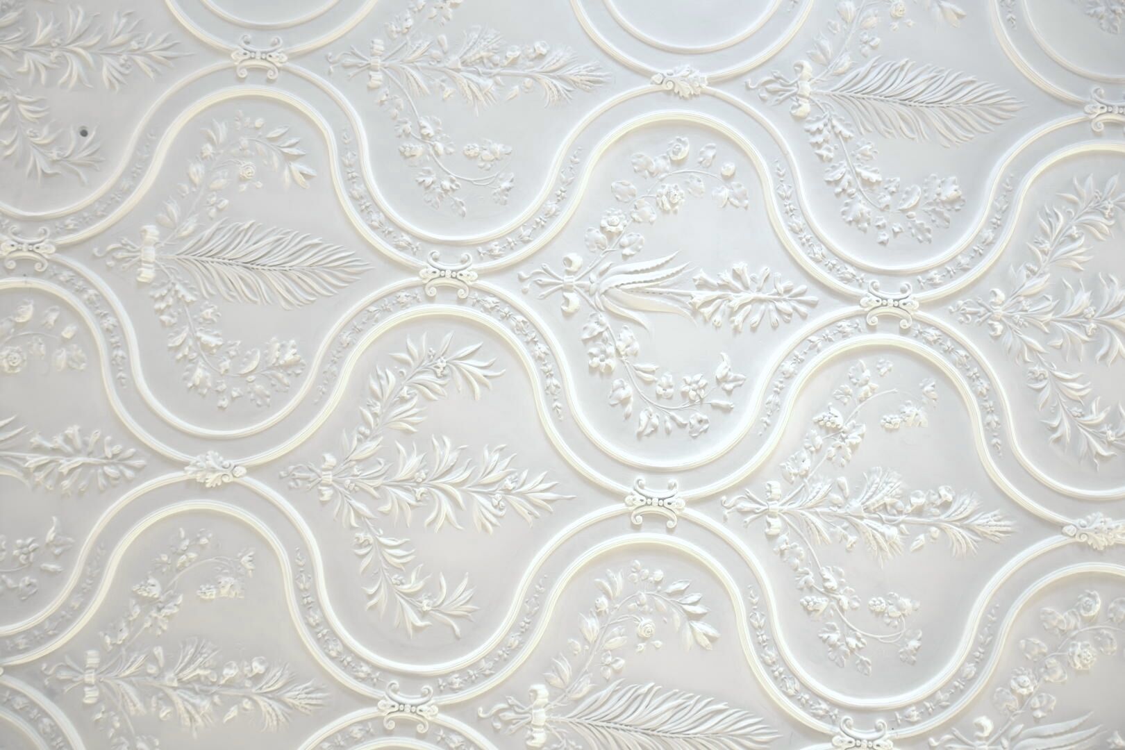 A detailed floral and leaf pattern on a ceiling.
