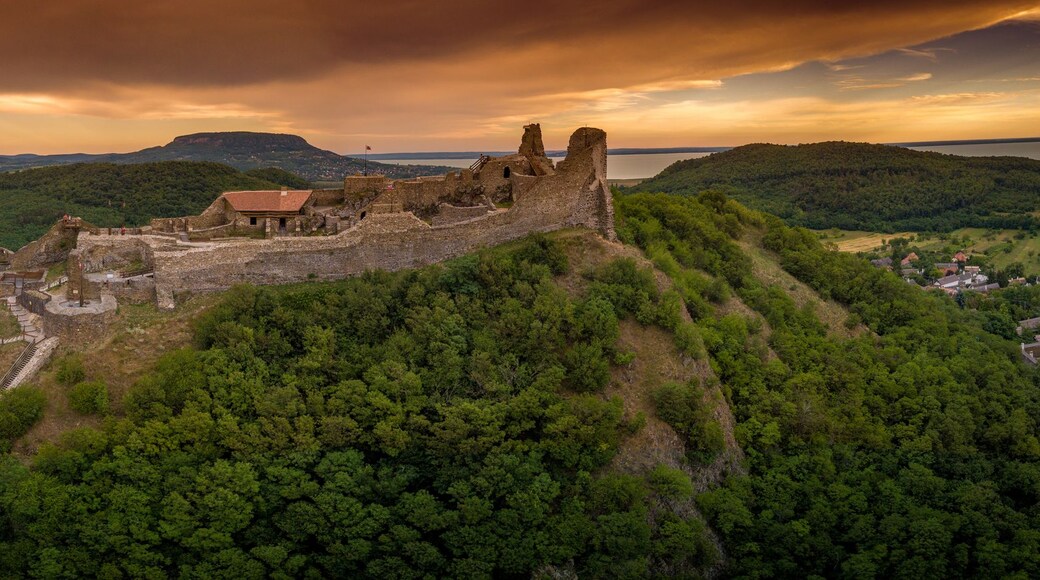 Aerial sunset panorama of ruined medieval Szigliget castle in Hungary above the Lake Balaton with orange yellow sky