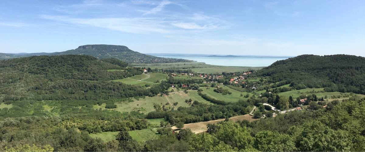 A valley with a lake, rolling hills, and scattered houses.