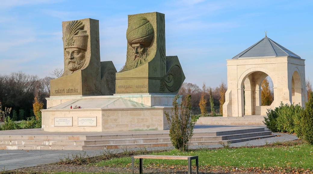 A monument with two large stone sculptures and a small pavilion.