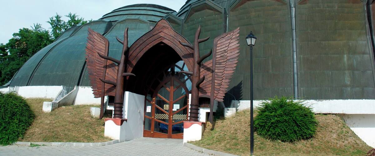 A building with a large dome and a winged entrance.
