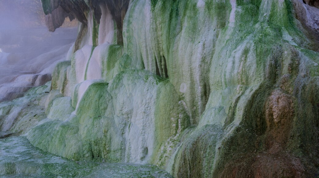 Egerszalók thermal terraces with green mineral layers and steam, showing unique natural geothermal formations and textured slopes.