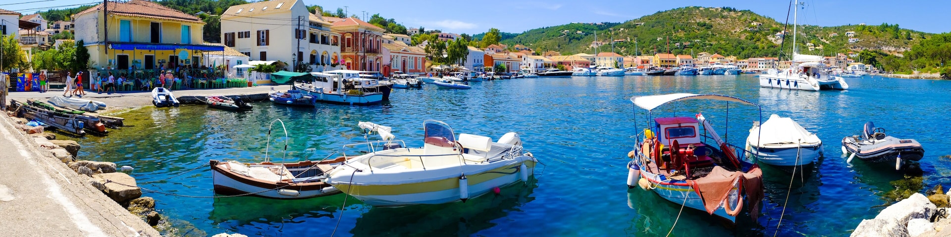 Un puerto con barcos amarrados, un muelle y edificios coloridos a lo largo de la costa.